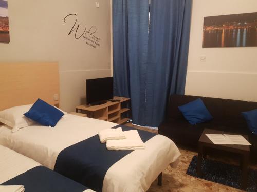 a living room with two beds and a couch at Le Malte House St. Julians in St Julian's