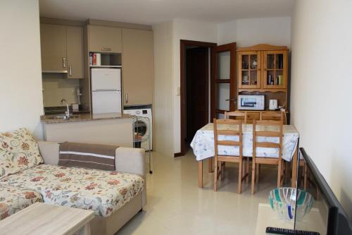 sala de estar y cocina con mesa y sofá en Apartamento San Roque, en Finisterre