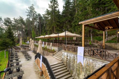 a patio with stairs and chairs and umbrellas at Hancioglu Orman Evleri & Hotel in Trabzon