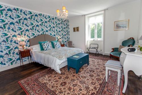 - une chambre dotée d'un lit avec un mur bleu dans l'établissement La Vieille Maison D'Aurin, à Bussière-Galant
