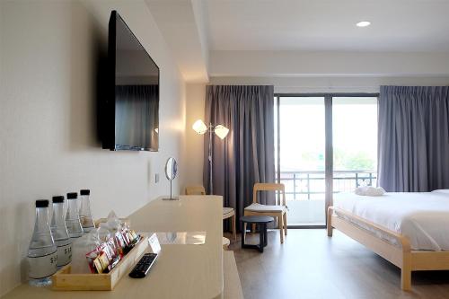 a hotel room with a bed and a desk with a desk at Siam Mansion - SHA in Hat Yai