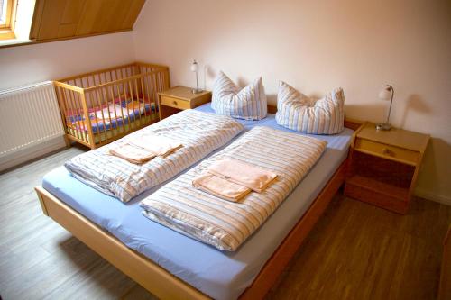 - une chambre avec 2 lits avec des oreillers et un lit bébé dans l'établissement BORKUMUNTERKUNFT - WOH6 - IM HERZEN DER INSEL, à Borkum