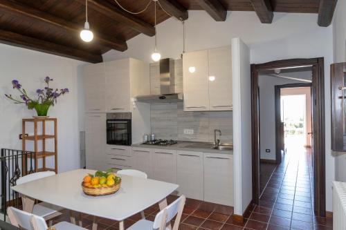 a kitchen with a table with a bowl of fruit on it at La Casazza - Country House in Rosolini