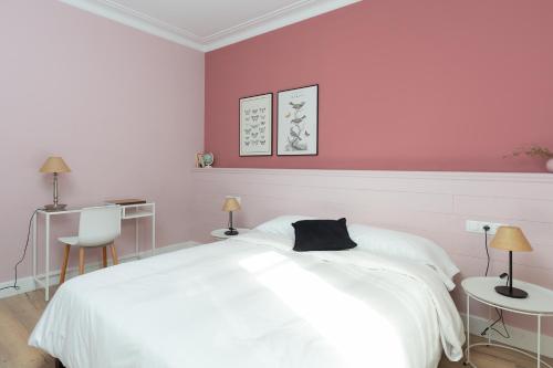 a bedroom with a white bed and a pink wall at Casa Cosi - Eixample 5 in Barcelona