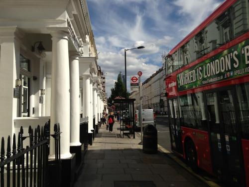 a red double decker bus on a city street at Lidos Hotel in London