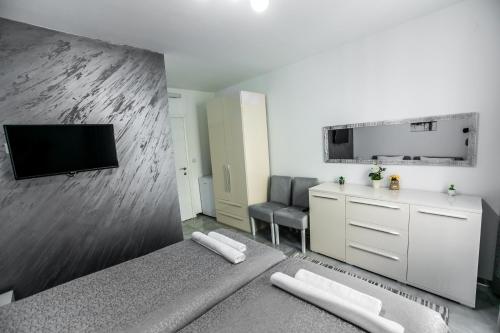 ein Wohnzimmer mit einem Bett und einem Flachbild-TV in der Unterkunft TREF in Prokuplje