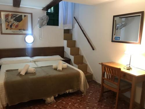 a bedroom with a bed and a stair case at Casa de Huespedes la Peña in Ibiza Town