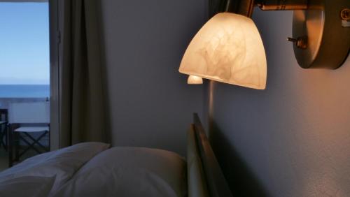 a lamp in a room with a bed and a window at Thea Apartment in Agia Marina Nea Kydonias