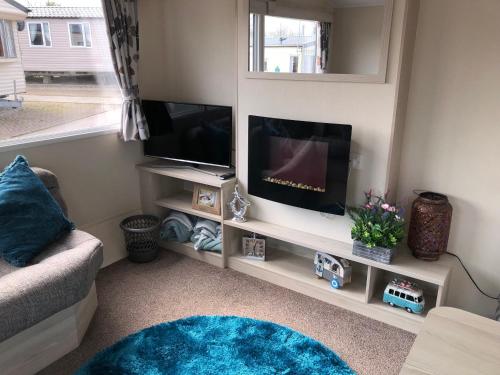 sala de estar con TV de pantalla plana y sofá en Marton mere en Blackpool