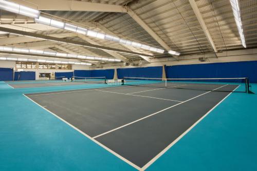 a tennis court in a gym with blue walls at Oh St Joseph Resort Hotel in West Atlantic City