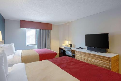 a hotel room with a bed, television and a desk at Quality Inn in Clinton