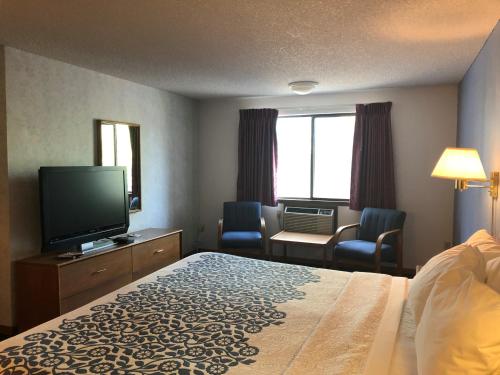 a hotel room with a bed and a flat screen tv at Days Inn by Wyndham Corvallis in Corvallis