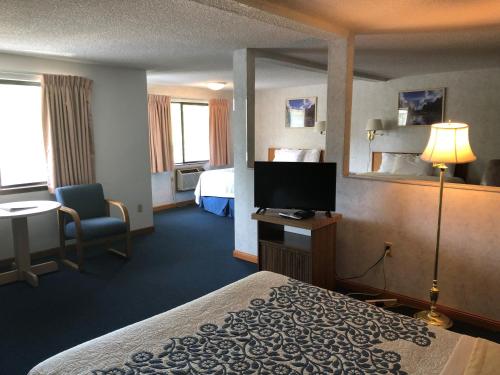 a hotel room with a bed and a flat screen tv at Days Inn by Wyndham Corvallis in Corvallis