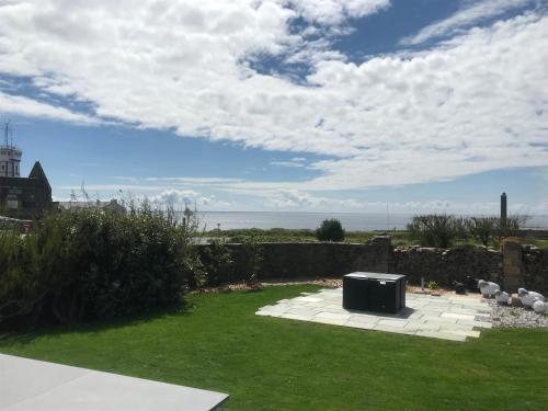 a backyard with a small appliance in the grass at Le Clos de la Pointe Saint-Mathieu in Plougonvelin