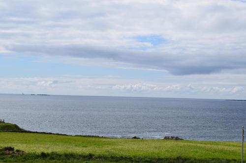 a view of the ocean from a grassy field at Le Clos de la Pointe Saint-Mathieu in Plougonvelin
