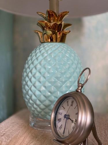 a clock sitting next to a vase with a pineapple at West End Inn in Portland