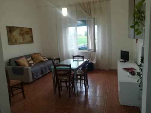 a living room with a table and chairs and a couch at Casa Melissa in Savio di Ravenna