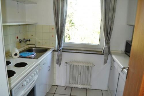 a kitchen with a sink and a stove and a window at Ferienwohnung Halligblick in Nieblum