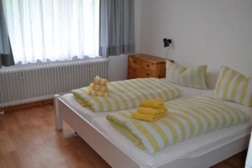 a white bed with yellow and yellow towels on it at Ferienwohnung Halligblick in Nieblum