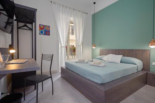 a bedroom with a bed, chair, desk and a lamp at Better & Better in Palermo
