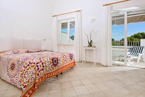 Hotel La Tosca في كابري: غرفة نوم بسرير وشرفة