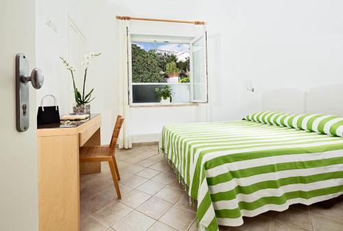 a bedroom with a bed and a desk at Hotel La Tosca in Capri