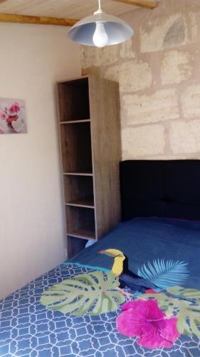 ein Schlafzimmer mit einem blauen Bett mit Blumen darauf in der Unterkunft L'Hibiscus in Talais