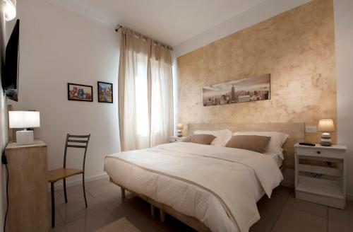 1 dormitorio con 1 cama blanca grande y escritorio en Le Suites - di fronte Ospedale Sacro Cuore, en Negrar