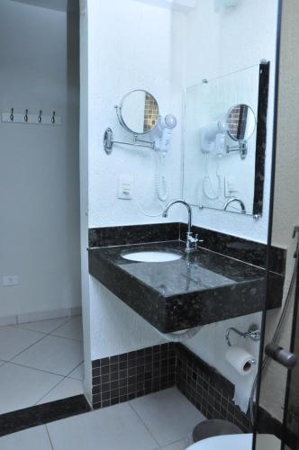 a bathroom with a sink and a mirror at Hotel Marajó in Uberlândia