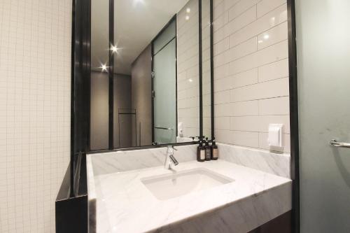 釜山にあるBrown Dot Hotel Seomyeonの洗面台と鏡のあるバスルーム