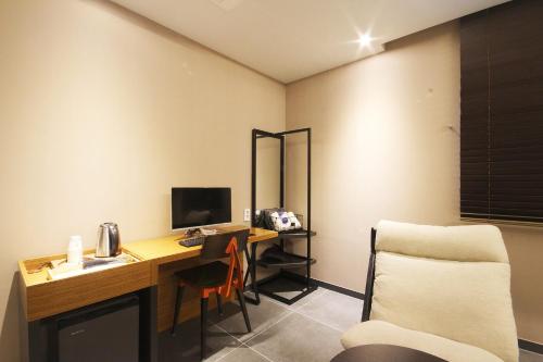 a room with a desk with a computer and a chair at Brown Dot Hotel Seomyeon in Busan