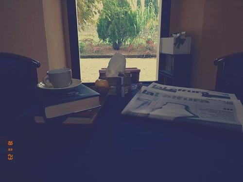 a room with a table with a coffee cup and a book at Hostel il Tetto in Melfi