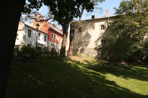 an old building with a tree in the grass at Hotel Gródek in Kraków