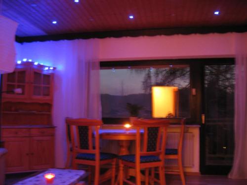 Pokój ze stołem i krzesłami z fioletowymi światłami w obiekcie Ferienhaus Wasgaublick w mieście Bundenthal
