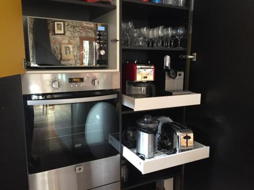 une cuisine avec une cuisinière et un micro-ondes dans l'établissement Maison de maitre, coeur de ville., à Sète