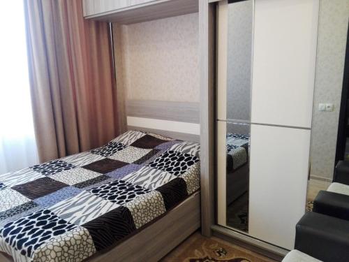 a small bedroom with a mirror next to a bed at var-ketili in Tbilisi City