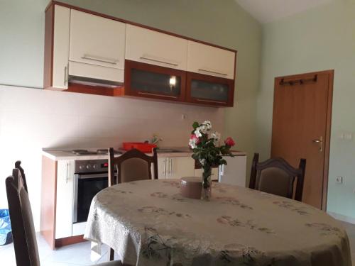 a kitchen with a table with a vase of flowers on it at Spirit in Međugorje