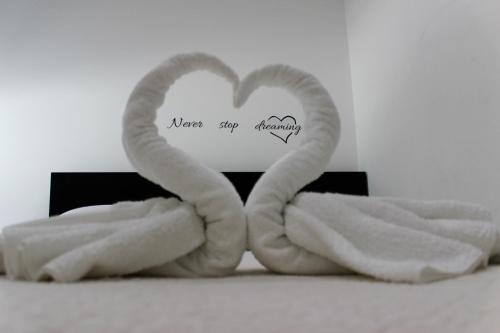 - deux serviettes et un panneau avec un cœur dans l'établissement Apartment Pino, à Pučišća