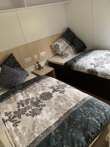 a room with two beds in a room at Mobilheim Murnersee Haus 5 in Wackersdorf