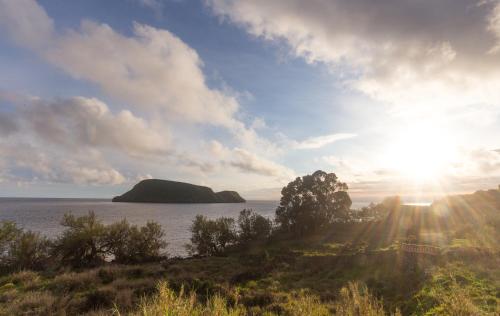 an island in the water with the sun in the sky at Casa do Galante in Porto Judeu