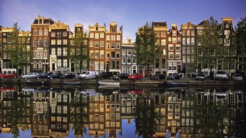 a group of buildings next to a body of water at Canal view suite in Amsterdam