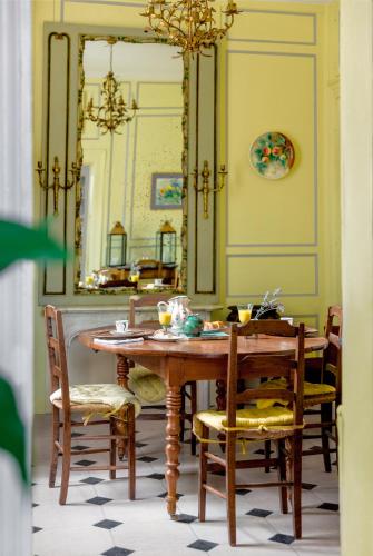 une salle à manger avec une table, des chaises et un miroir dans l'établissement La Maison Charmante, à Châtellerault