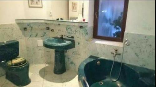 a bathroom with a green sink and a tub at Rooms in the apartment-center in Košice