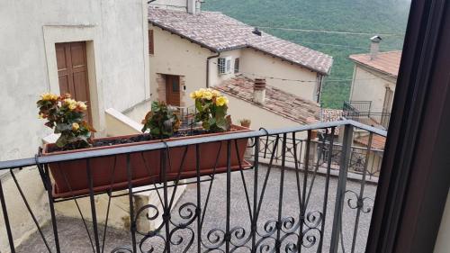 a balcony with flowers in a pot on a building at La casetta dei Desideri in Poggio Bustone