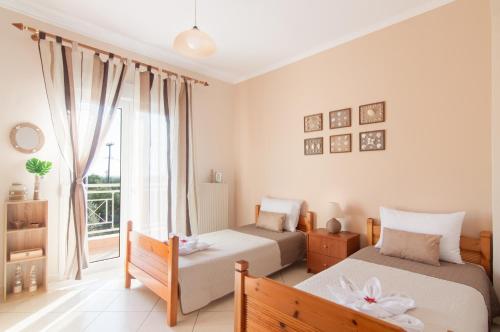 um quarto com 2 camas e uma janela em Panoramic View House em Skala Kallirachis
