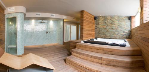 uma casa de banho com jacuzzi e parede de tijolos em Lagaya Apartaments & Spa em Valderrobres