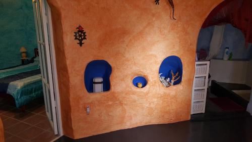Zimmer mit einer Wand und blauen Fenstern in der Unterkunft Casa-Cueva Nijar in Níjar