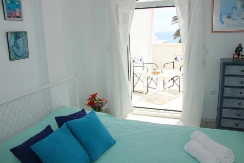 1 dormitorio con 1 cama con almohadas azules y balcón en La Playa Blanca 4, Duquesa, Beach, Sea View, Pool, WiFi, en Torrevieja