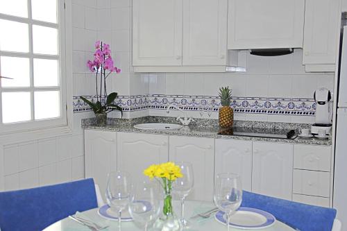una cocina con una mesa con copas de vino. en La Playa Blanca 4, Duquesa, Beach, Sea View, Pool, WiFi, en Torrevieja