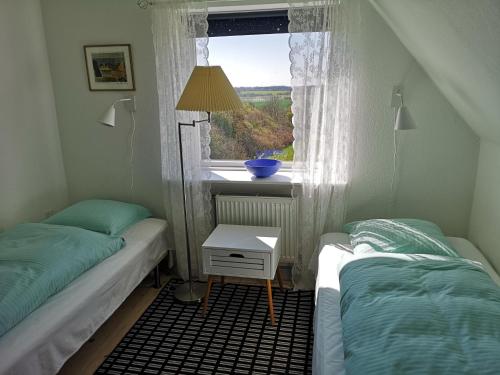 two twin beds in a room with a window at Rosenhuset in Haderslev